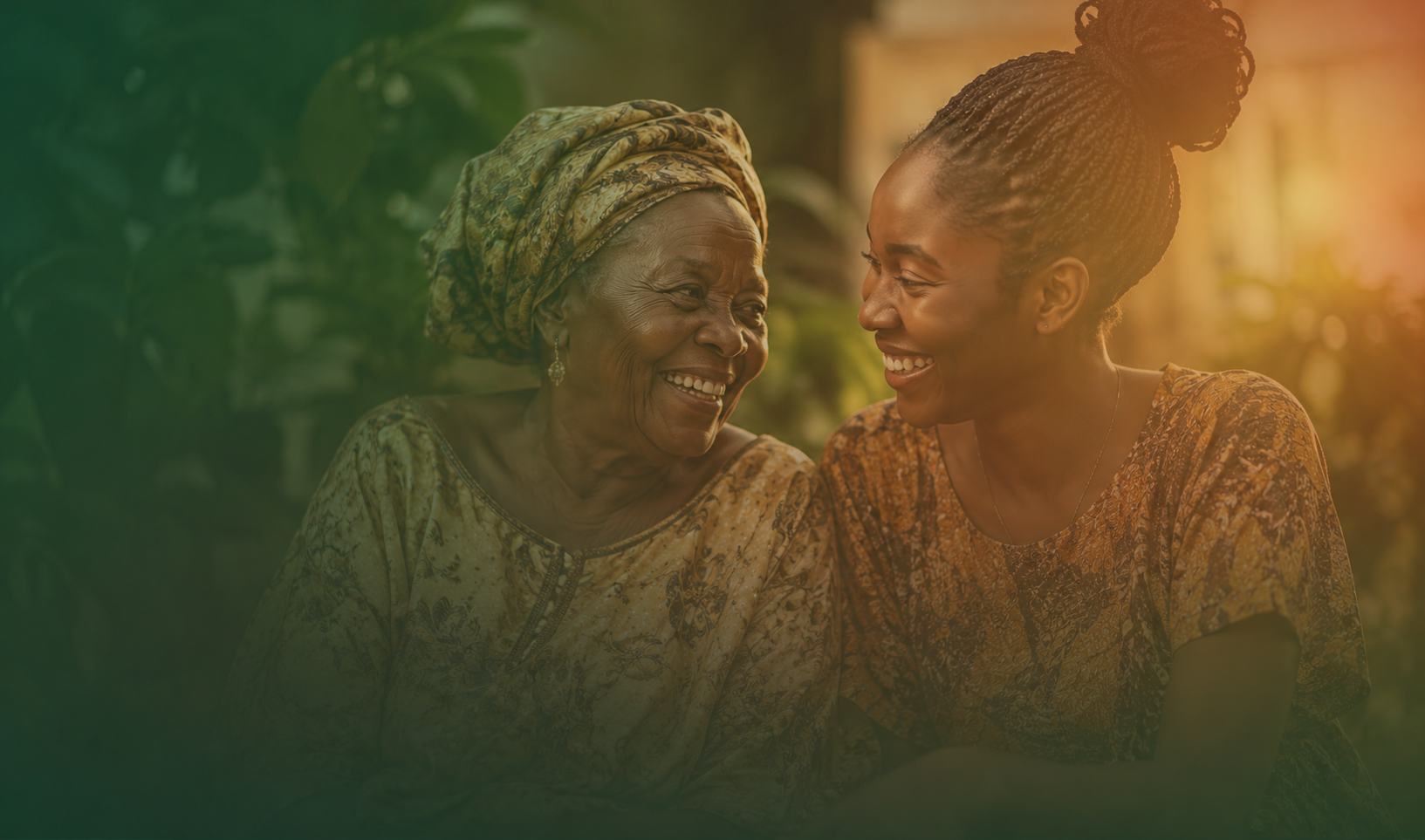 A grandmother and a young woman sitting together, laughing.